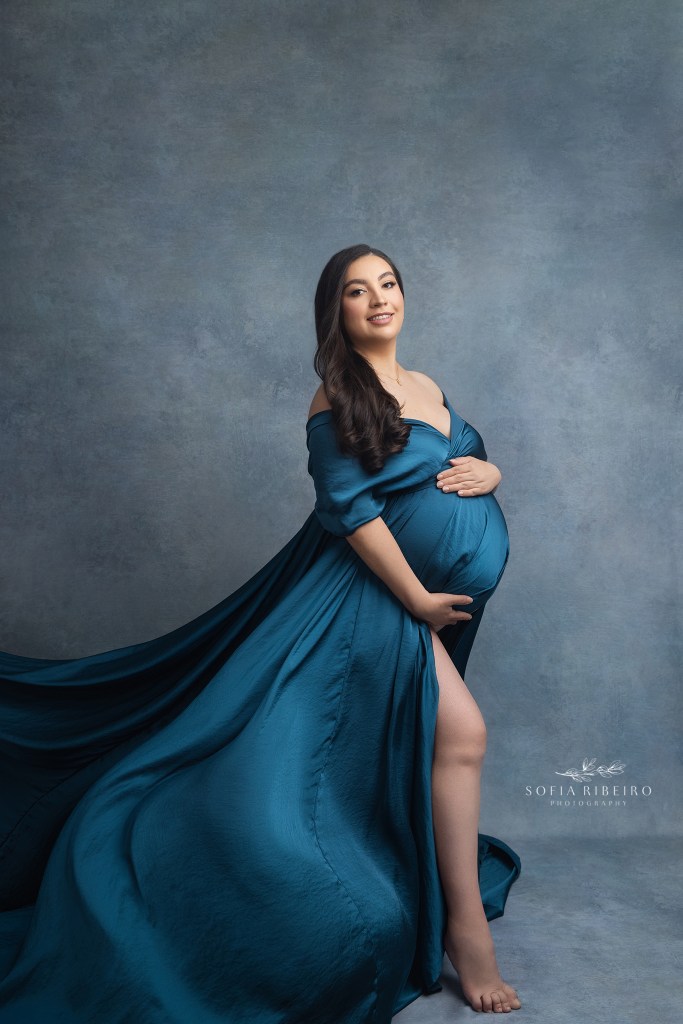 mom is draped in a gorgeous flowing blue fabric by maternity photography studio in hackensack nj