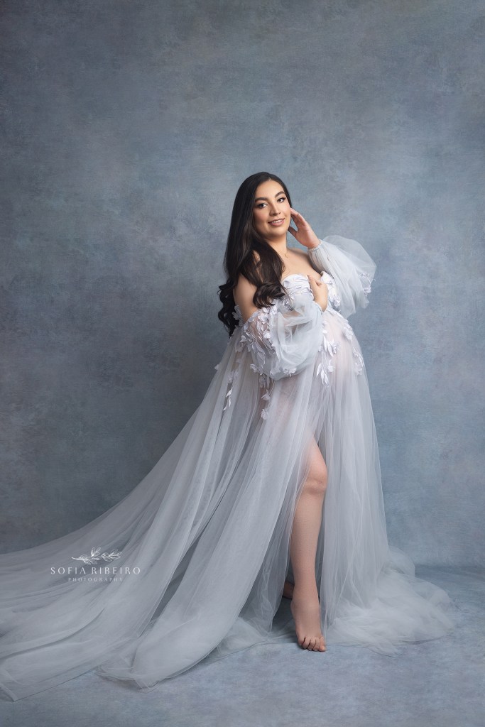 mom gently touches her cheek while cradling her belly during maternity photos in hackensack nj