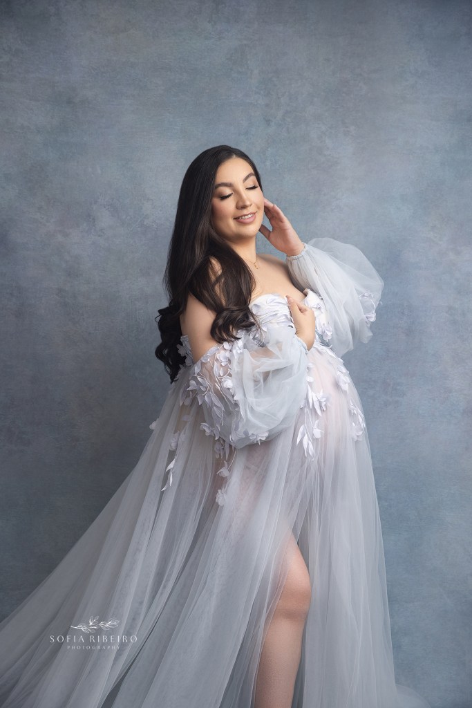a graceful portrait of an expecting mom wearing a soft blue gown