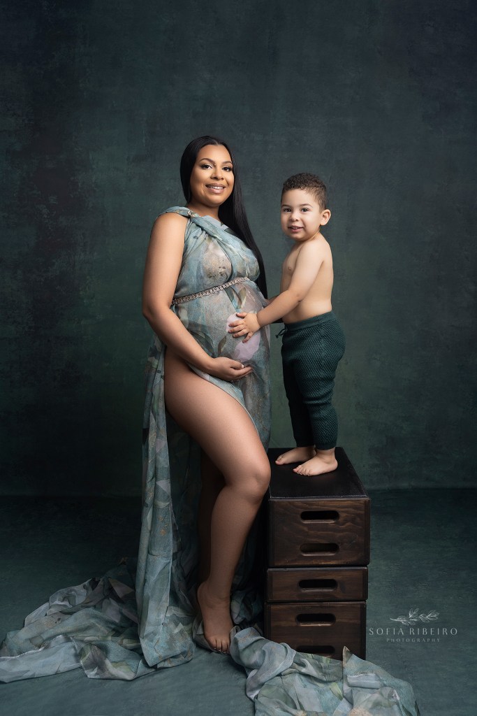 mom and bib brother smile together at the camers