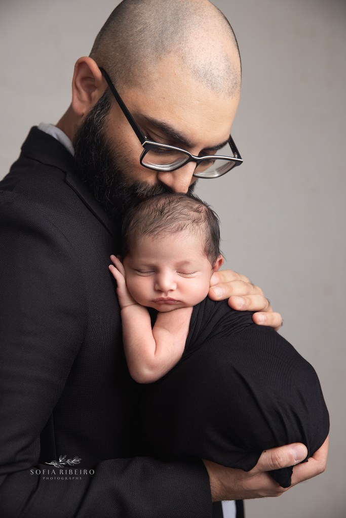 pennsylvania newborn photographer captures a shot of dad kissing baby sweetly on the head