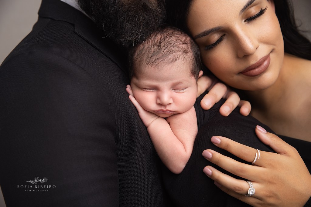 a closeup of a dad and mom snuggling together with a new baby during a photo session with a pennsylvania newborn photographer