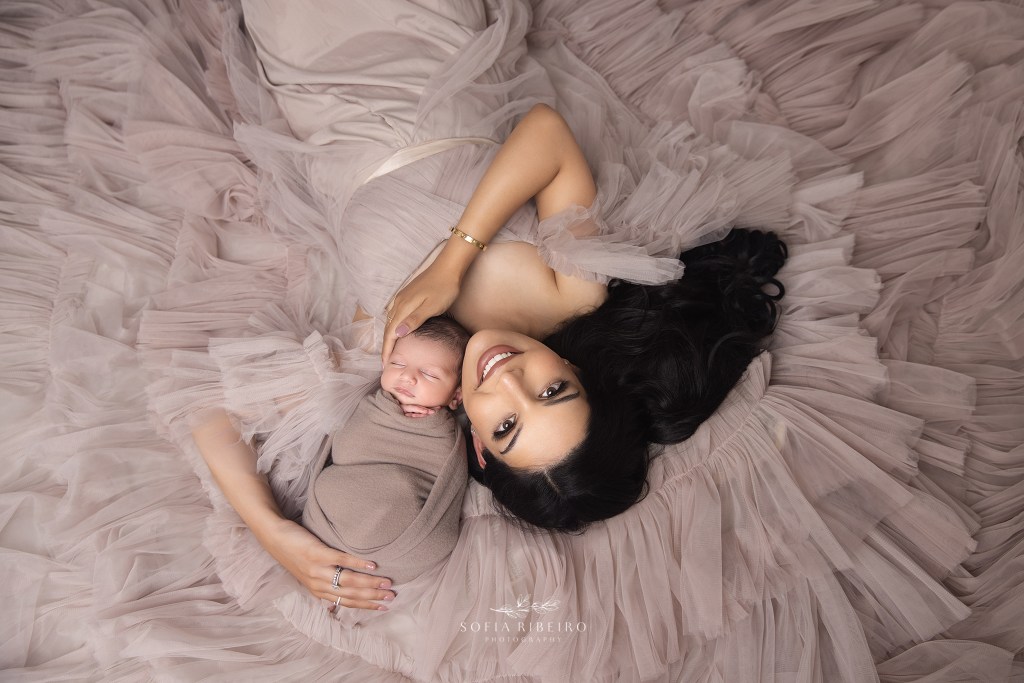 mom and baby share a snuggle on a bed of tulle