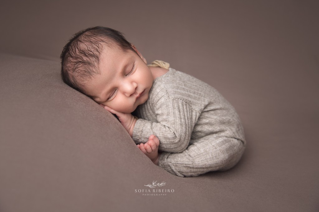 sleeping baby boy in a neutral outfit has his portrait taken during a photo session with a pennsylvania newborn photographer