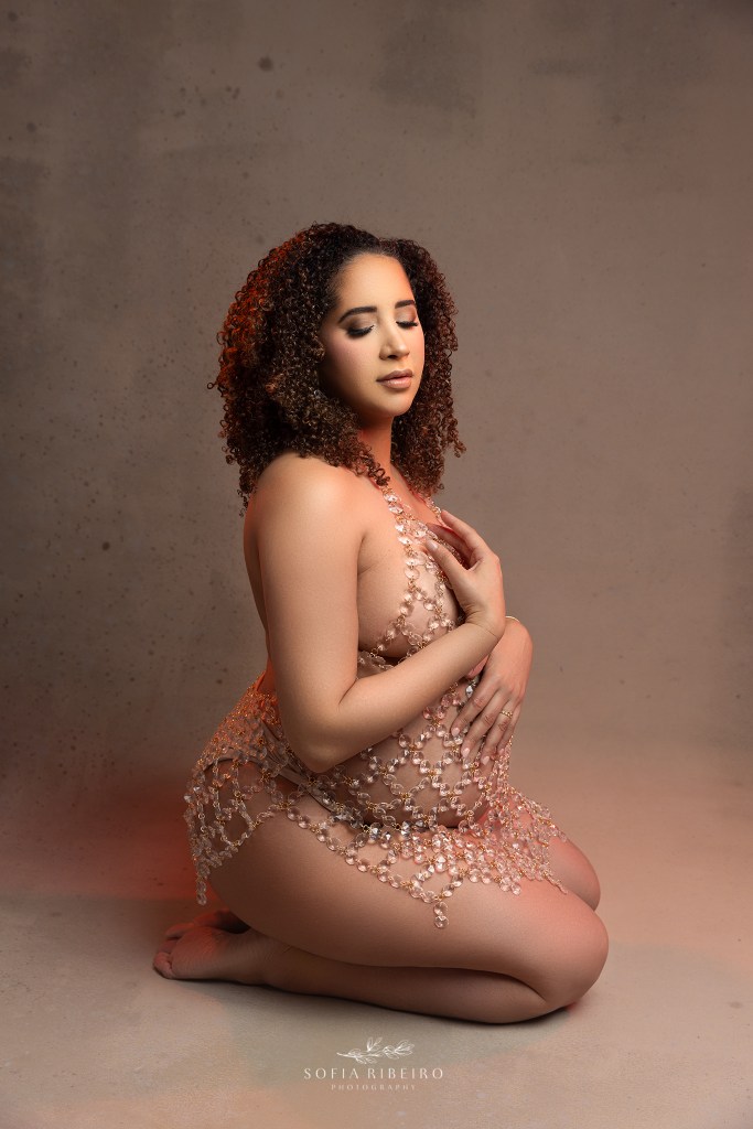 mom poses delicately on the floor in a crystal dress highlighting her bump