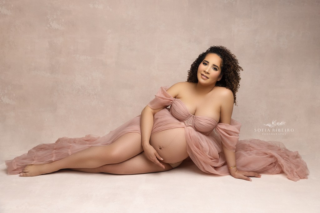 mom looks to camera while posing for belly portraits with saddle river nj maternity photographer