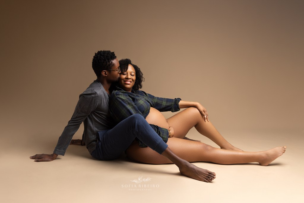 mom and dad share a tender moment, sitting together with belly exposed for union city nj maternity photographer