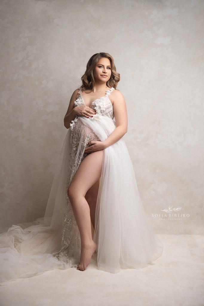 mom holds her belly gingerly, during a mayternity session with a hillsborough nj maternity photographer