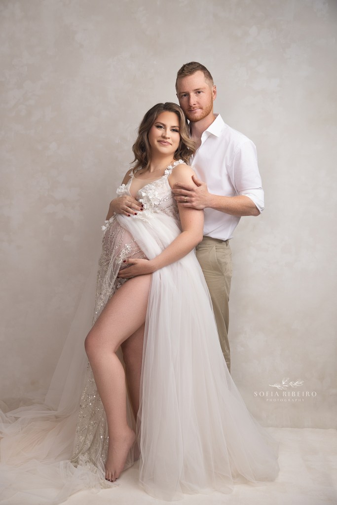 a striking pose of expectant mom with dad holding onto her