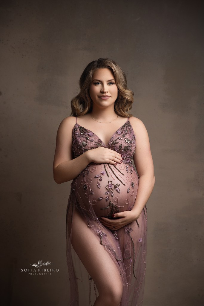 mom strikes a pose cradling her belly for a maternity potrait