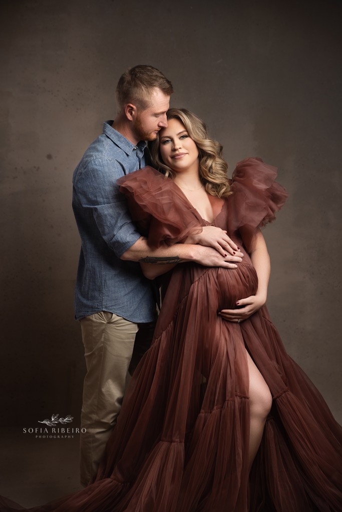 mom and dad snuggle together in shades of brown