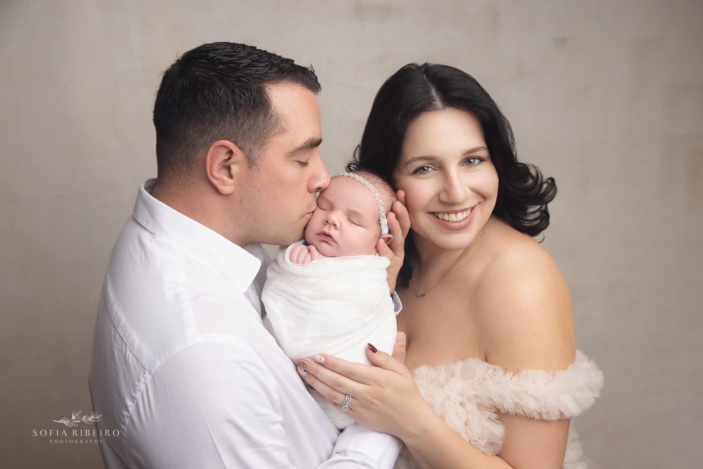 a bernards nj newborn photographer poses parents snuggling sweetly with their new baby girl