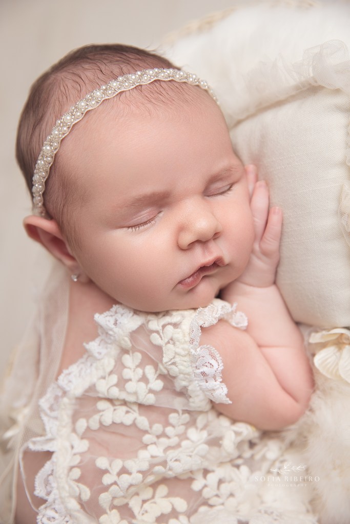 a closeup portrait of a sweet baby girl dressed in cream