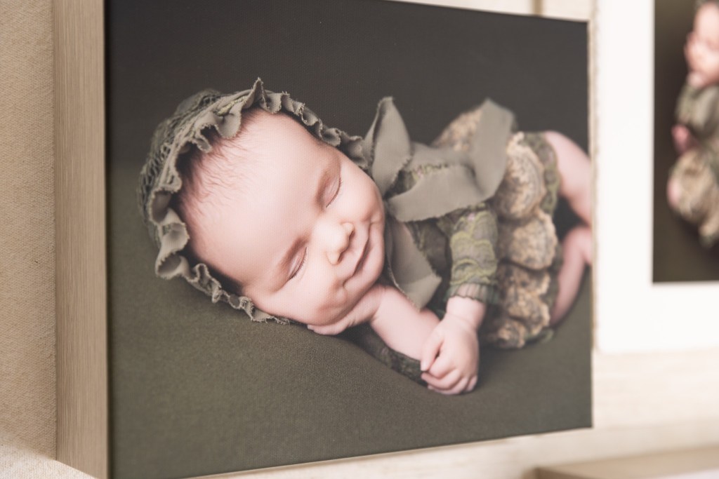a smiling baby on a soft canvas art piece from a nj newborn photo session