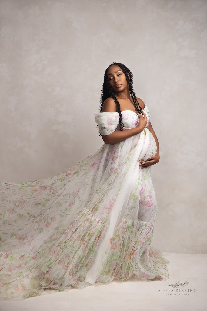 mom is draped in a romantic ballgown highlighting her baby bump for maternity photos