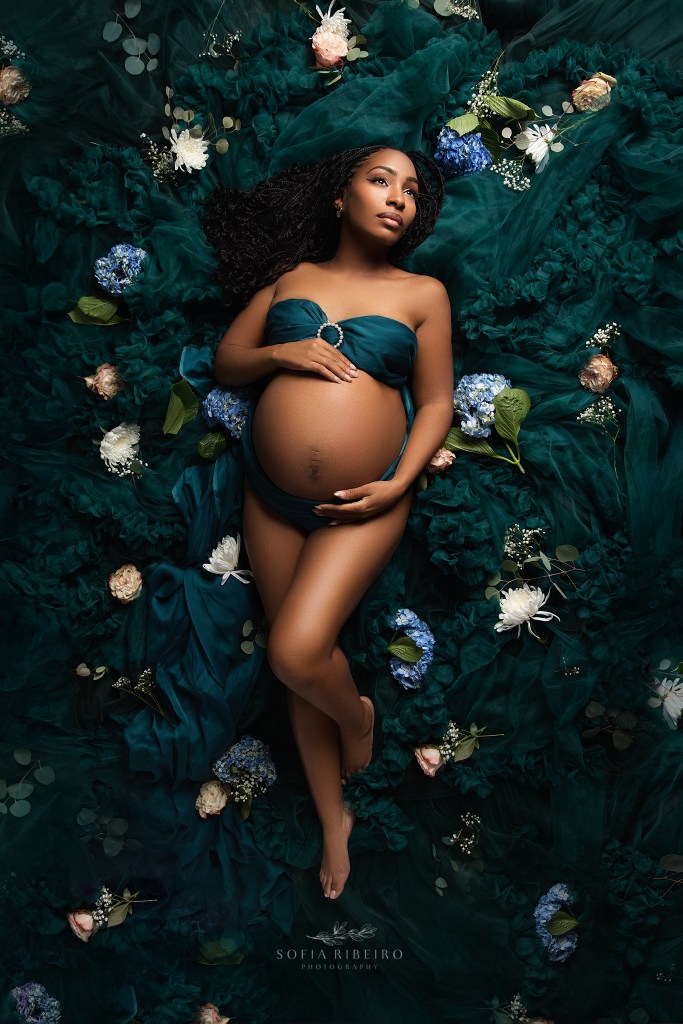 a somerville nj maternity photographer captures a mom in glowing splendor nestled in emerald green tulle and flowers