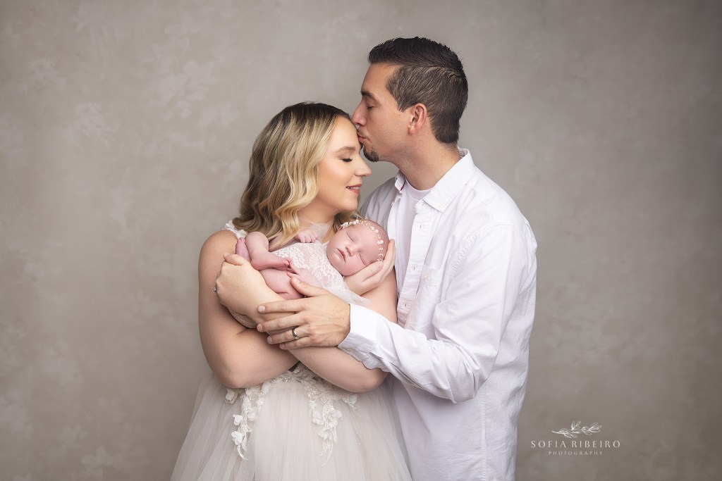 mom and dad pose together in a sweet image with their baby girl taken in a south plainfield nj newborn photography studio