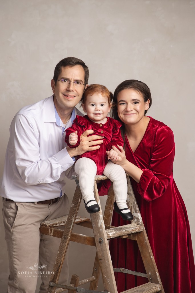 mom dad and 1 year olf baby sister smile to the camera for a family photo session in wallington nj