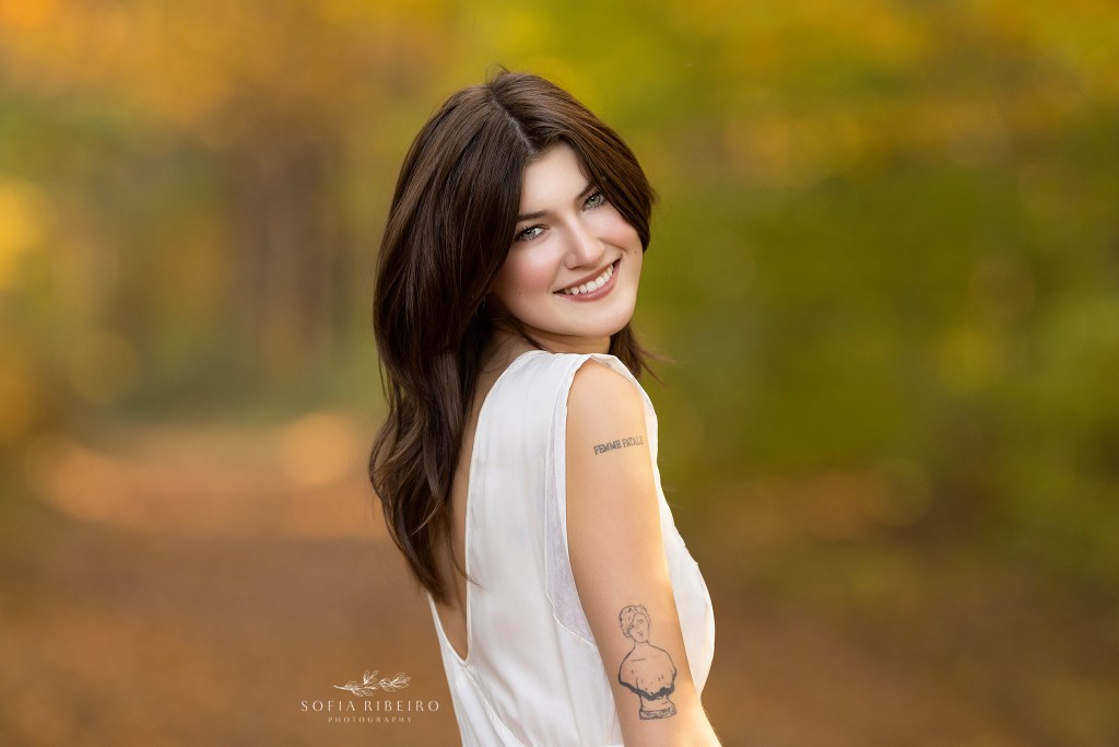 warren nj family photographer captures a portrait of a young adult female looking over her shoulder in the fall.