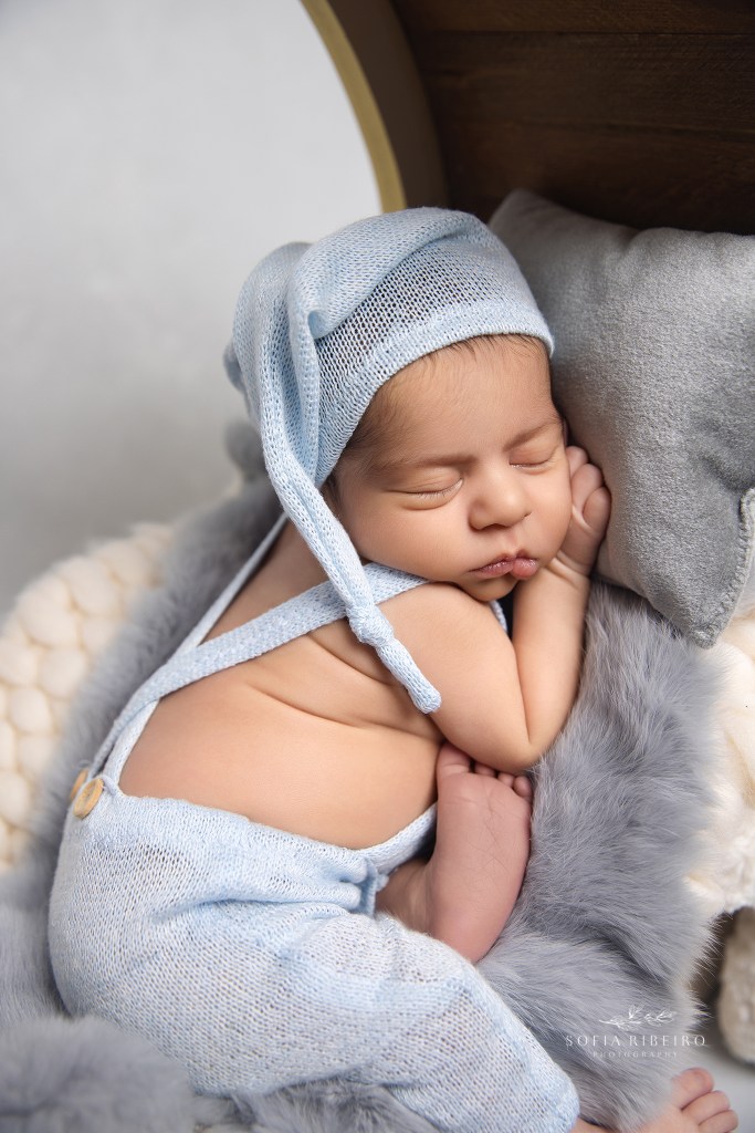 newborn baby boy sleeps sweetly on a grey pillow