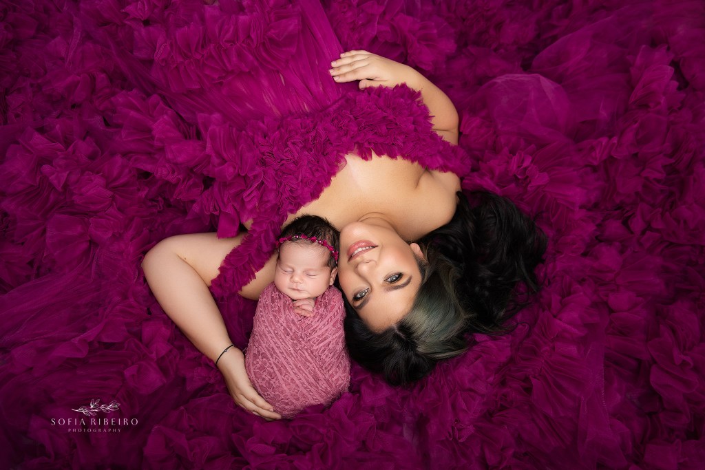 hanover nj newborn photographer poses mom and baby in a bed of pink tulle