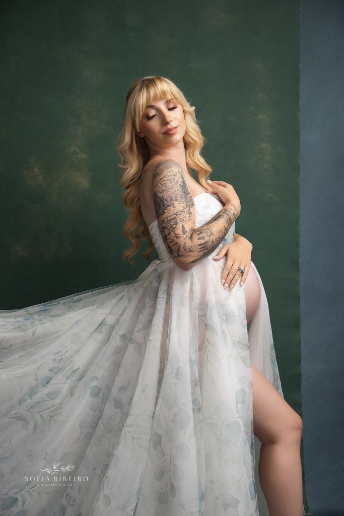 mom poses delicately in a green floral gown showcasing her tattoos for a randolph nj maternity photographer