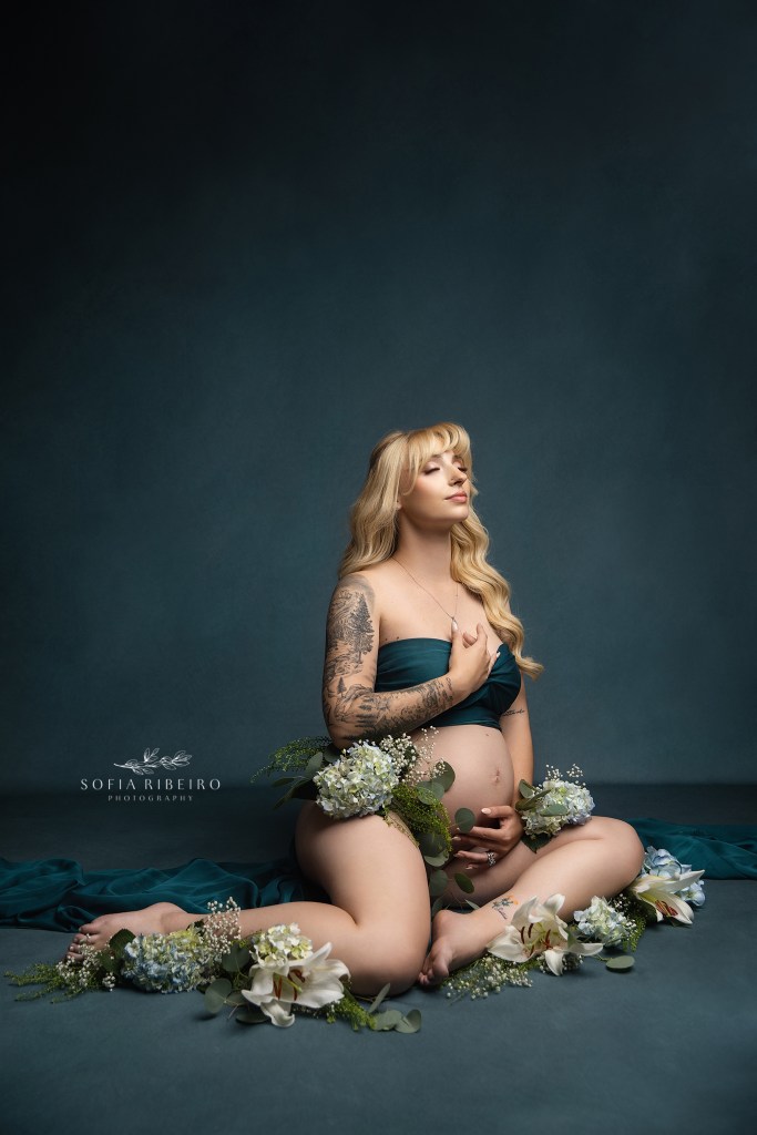 ethereal mom poses for maternity photos in randolph nj with flowers and green fabric