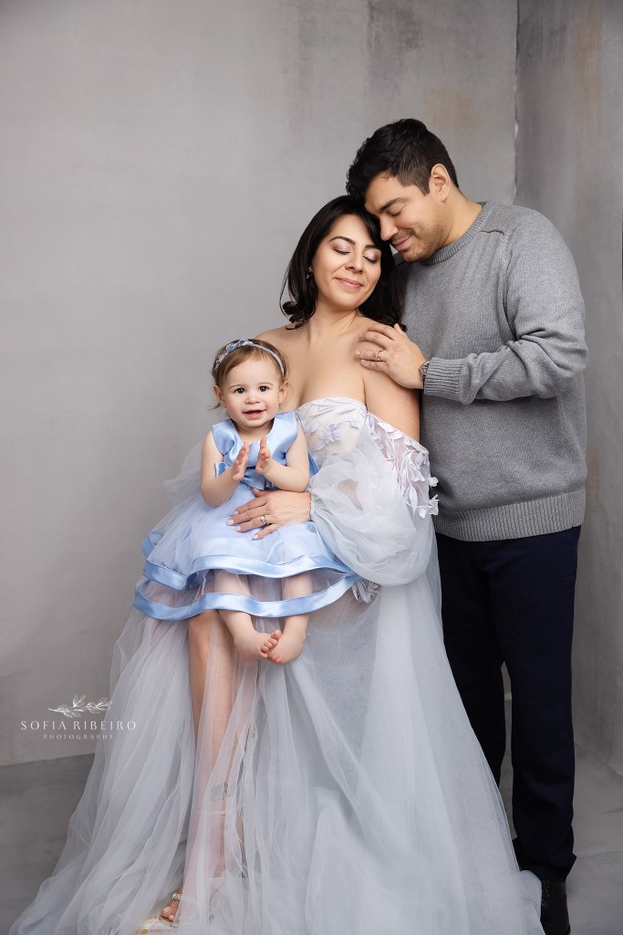 a family shares a warm embrace in hues of blue and grey for a portrait with summit nj family photographer