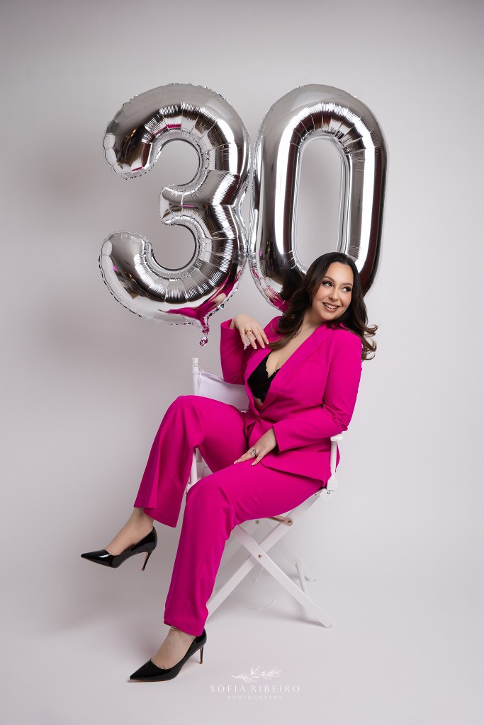 a 30th birthday portrait featuring a hot pink suit and silver number 30 balloons during a portrait session with a nj photographer