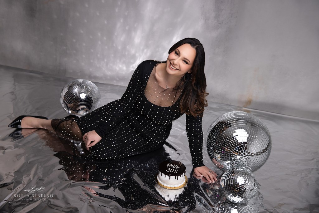 birthday girl poses among disco balls in a beaded dress to celebrate her 30th birthday
