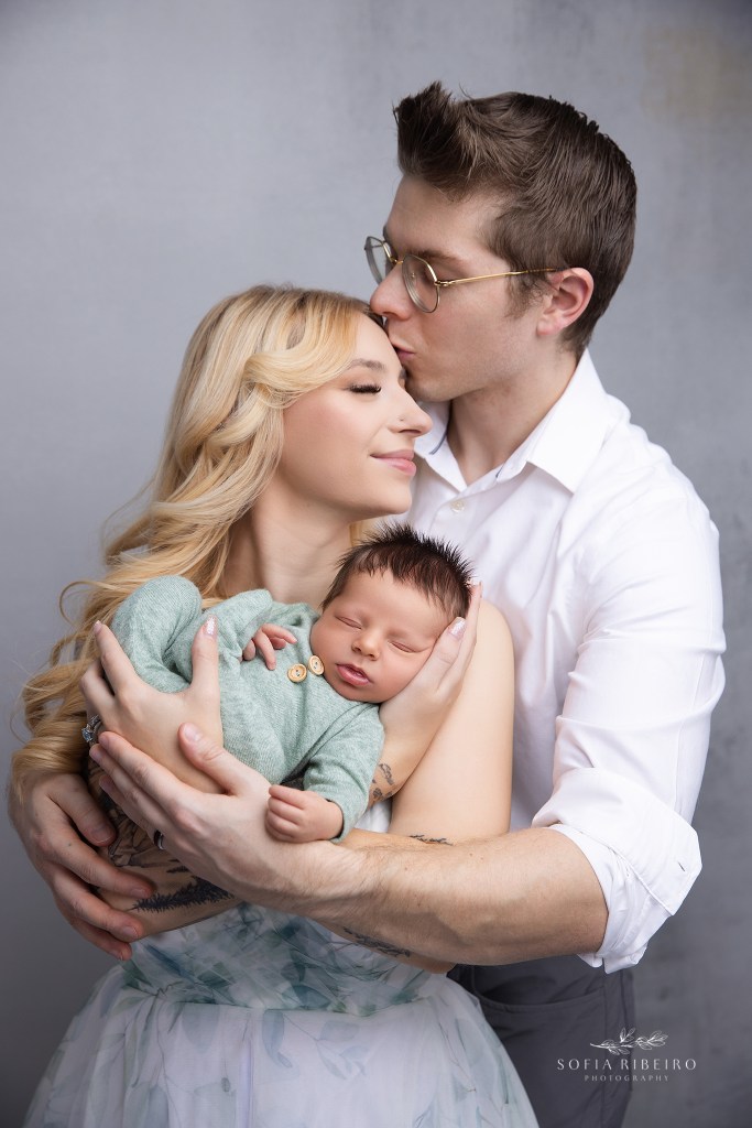 mom and dad share a sweet moment with baby while posing for a dover nj newborn photographer