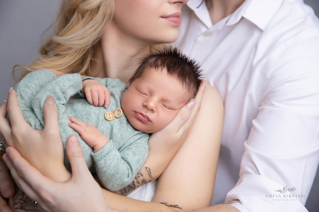 a closeup of baby's tiny features in parents' hands