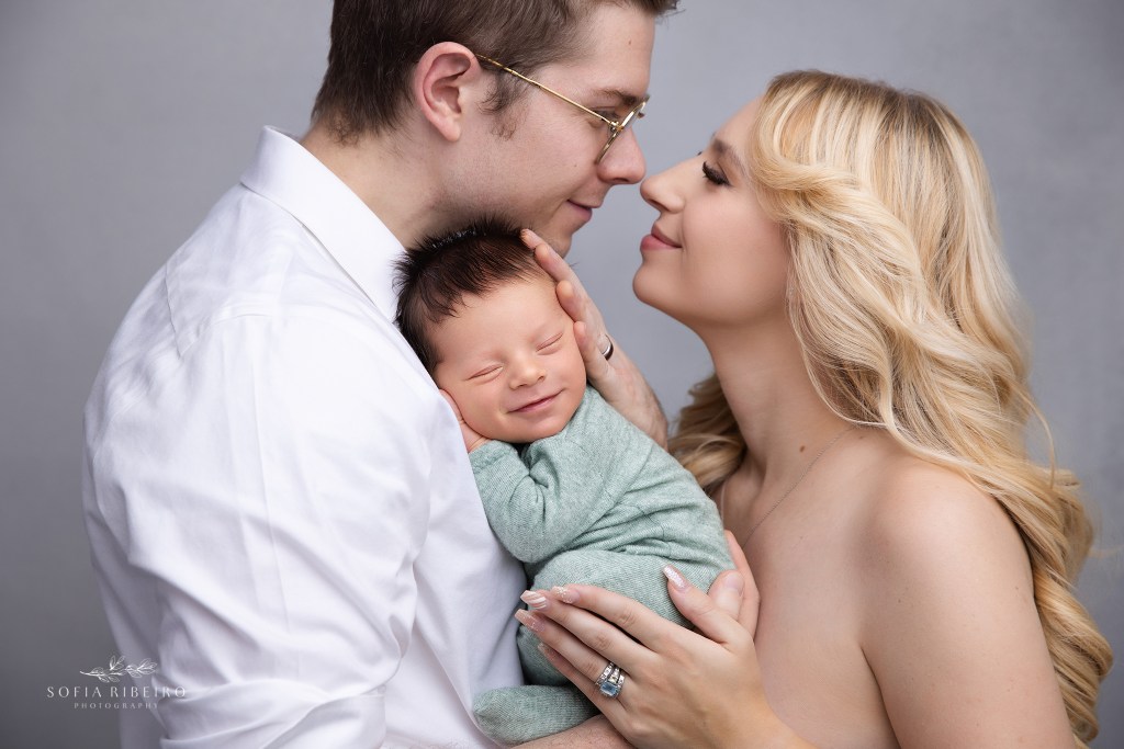 mom and dad sweetly snuggle their baby boy for a photo