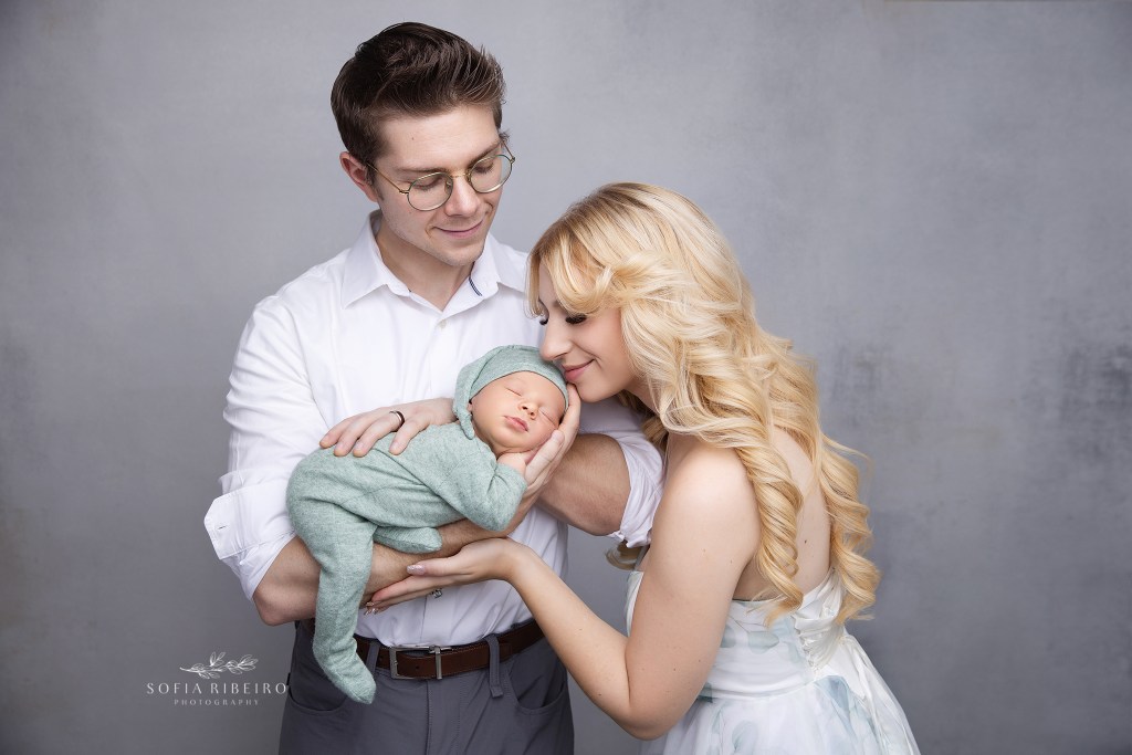 mom and dad sweetly snuggle their baby boy for a photo