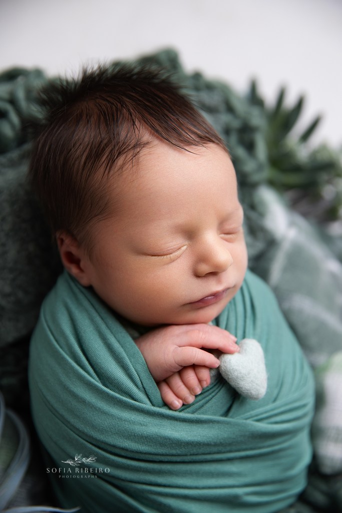 baby sleeps sweetly snuggling a little felted heart in dover nj