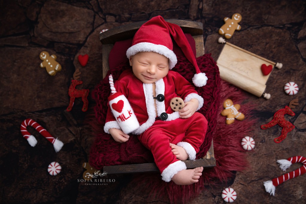 dover nj newborn photographer captures a smiling newborn baby boy in a santa suit and christmas themed newborn set