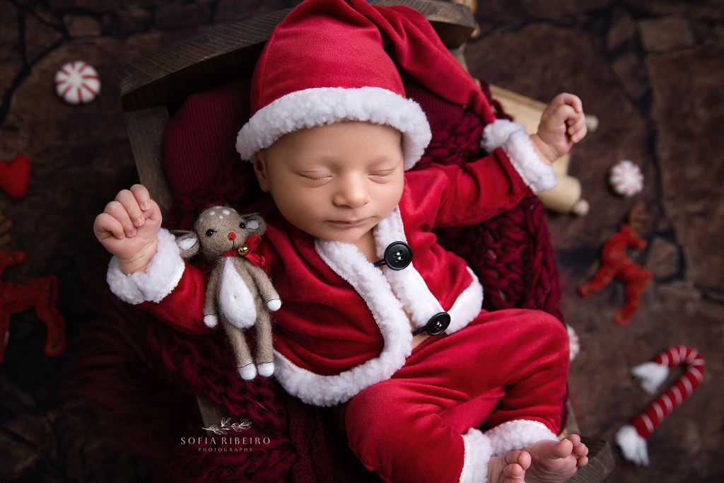newborn baby boy in a santa suit setup