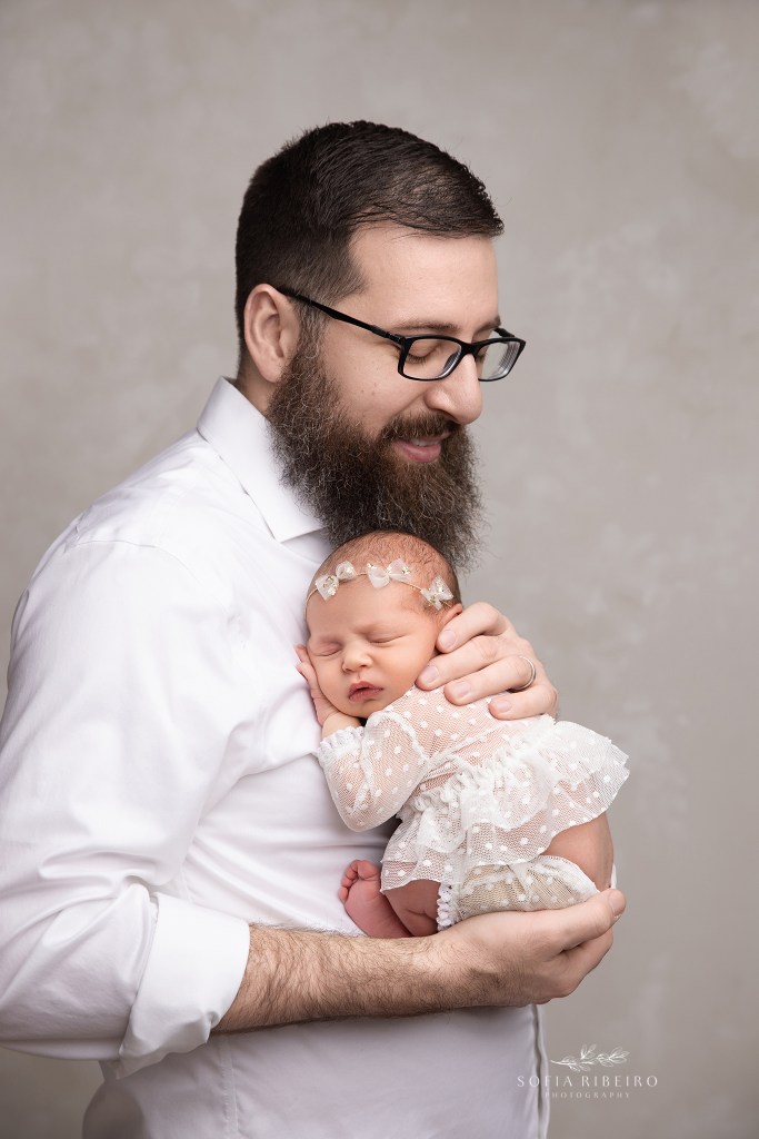 dad snuggles his new baby daughter sweetly for a portrait in dunellen nj