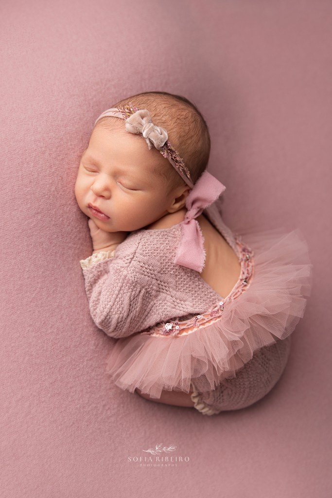 dunellen nj newborn photographer captures a baby girl dressed in a pink tutu outfit, sleeping in a curled up pose