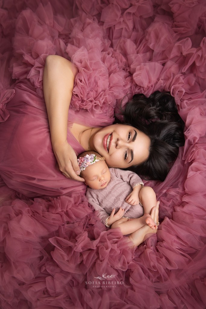 dunellen nj newborn photographer captures a portrait of mom with her baby girls nestled in pink ruffles
