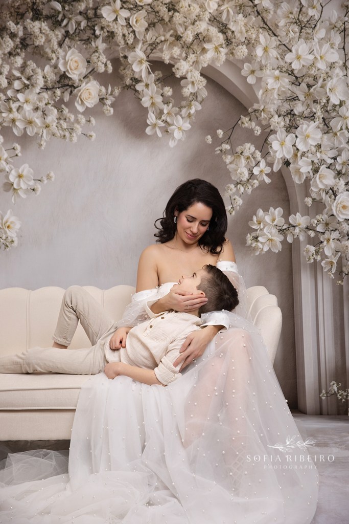 little boy lies in moms lap looking up at her for mommy and me portraits in nj