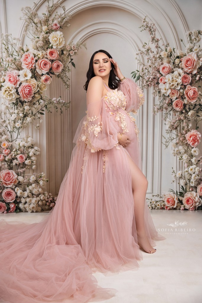 hudson valley ny maternity photographer captures a mom in a pink floral dress against a matching backdrop