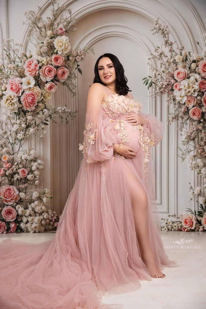 hudson valley ny maternity photographer captures a mom in a pink floral dress against a matching backdrop