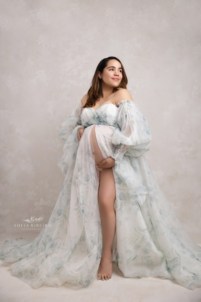 mom poses in a flowing eucalyptus printed gown for maternity portraits in lodi nj