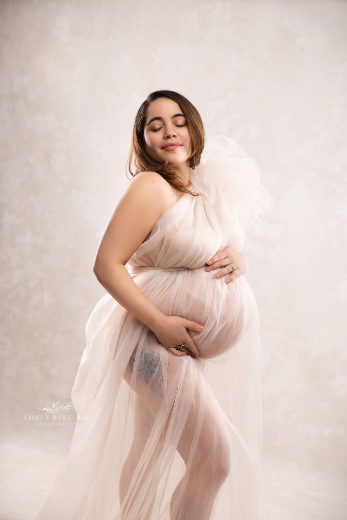 lodi nj maternity photographer captures mom to be in a swath of delicate tulle against some backlighting