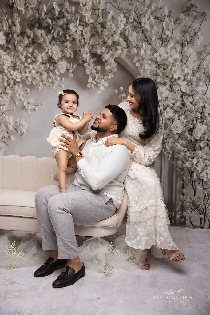a family of three share a happy moment with their 1 year old baby girl during a family photo session in staten island ny
