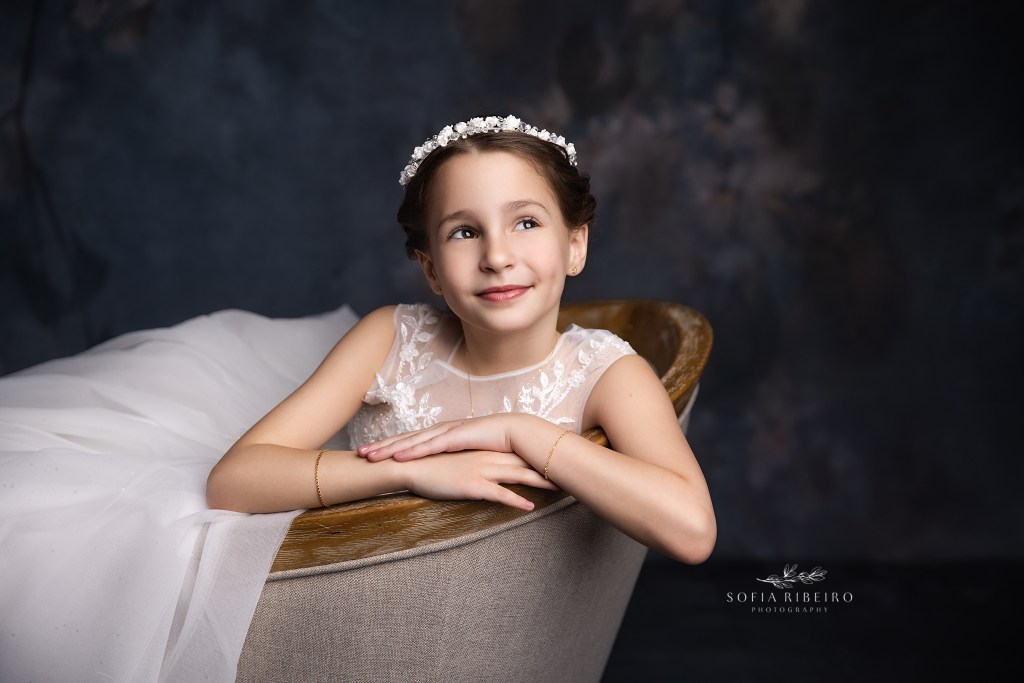 a closeup of a girl's communion portraits, with a more relaxed pose in a chair showing personality