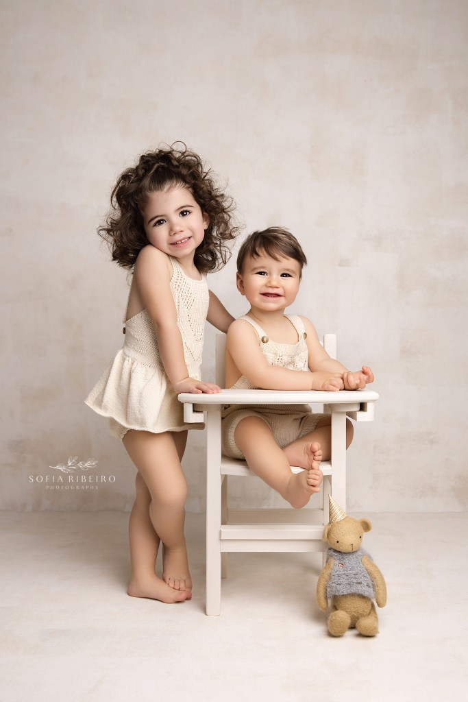 brother and sister pose together for a smiling portrait to celebrate their birthdays with a red bank nj photographer