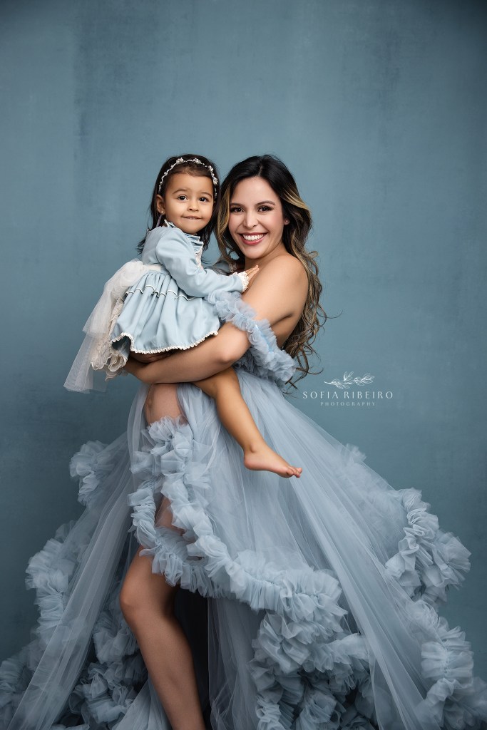 mom and older baby daughter snuggle together in a sweet pose, exposing the belly in a glen ridge maternity studio