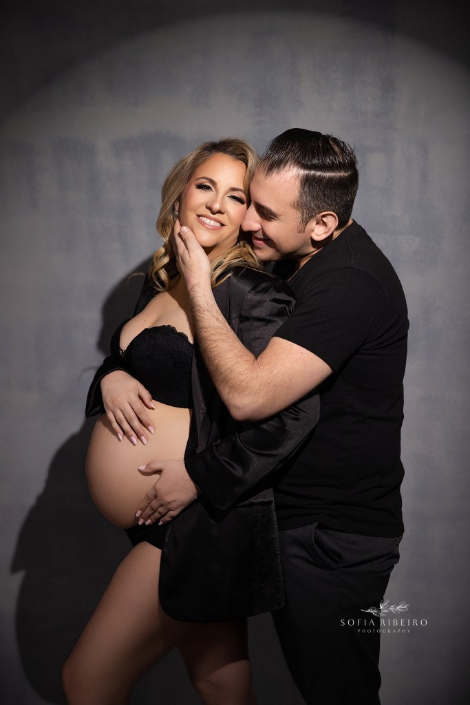 a maternity photographer in middletown nj captures a portrait of mom and dad to be in black matching outfits